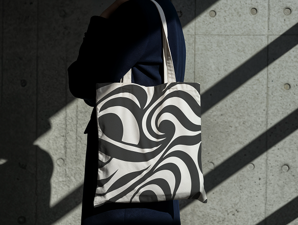 Somebody holding a tote bag with the GWD design on it. 